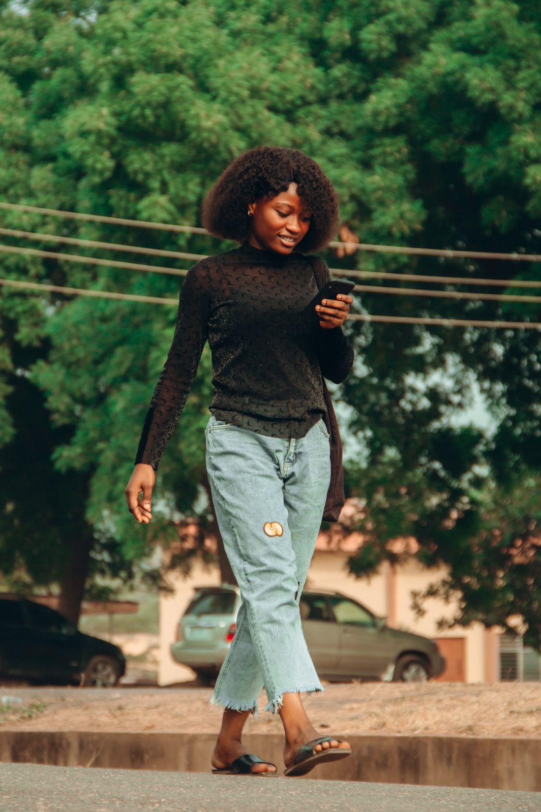 African woman holding a smartphone on a street